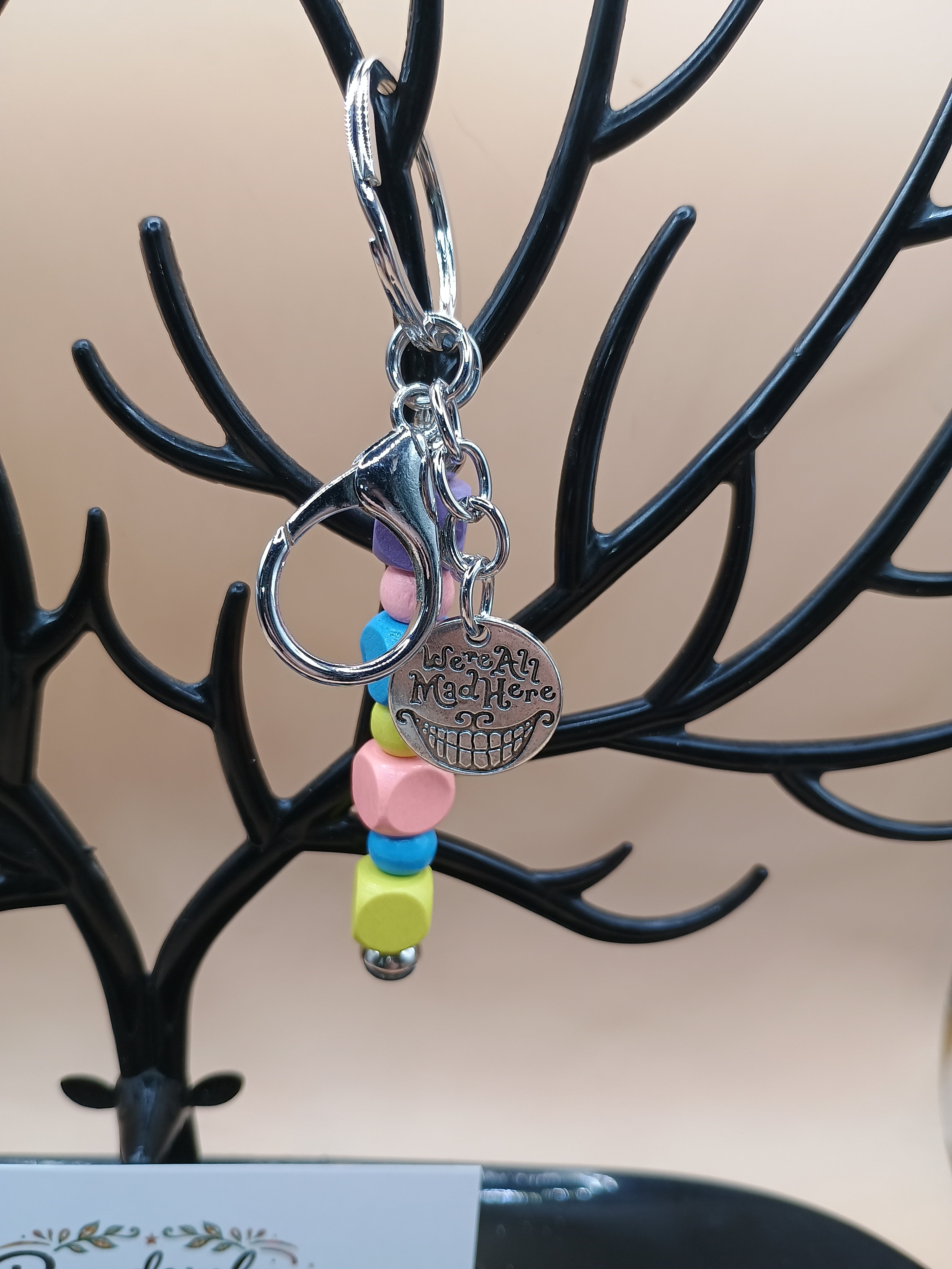 “We’re All Mad Here” Beaded Keychain – Silver Metal Keychain with Cheshire Smile Charm